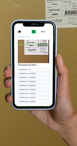 A hand holding a smartphone with QWeb mobile barcode scanning